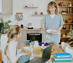 nursing student and parent brings sandwich to young daughter at dining room table