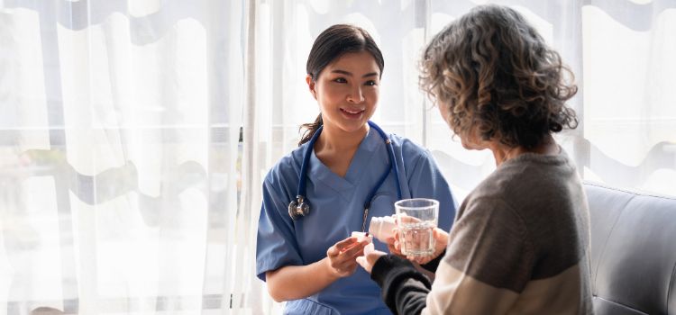 family nurse practitioner sits down with a patient and gives them medication