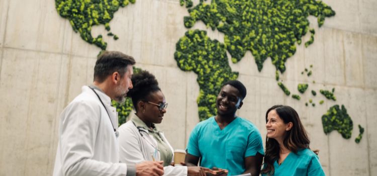 global nurses and doctors converse in front of a mural of the world